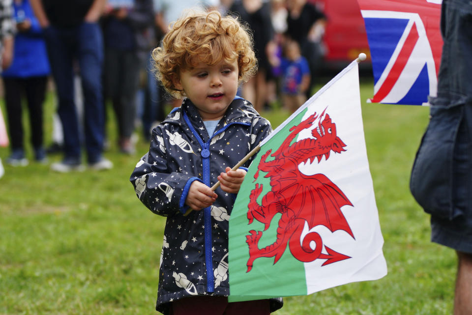 Elliot Gray, 2, waves the Welsh national flag ahead of the Accession Proclamation Ceremony at Cardiff Castle, Wales, publicly proclaiming King Charles III as the new monarch, Sunday Sept. 11, 2022. (Ben Birchall/PA via AP)
