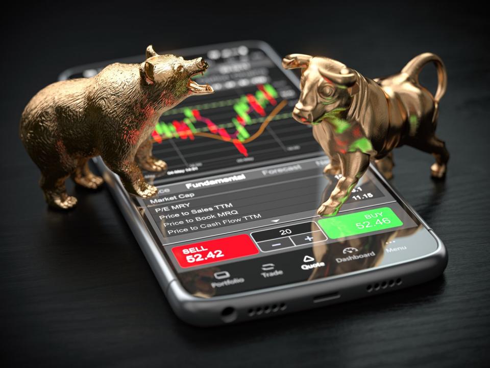 Statues of bull and bear trading stocks on a phone.