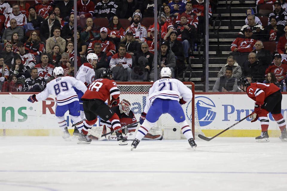 Montreal Canadiens right wing Joshua Roy (89) scores a goal past New Jersey Devils goaltender Nico Daws during the second period of an NHL hockey game Wednesday, Jan. 17, 2024, in Newark, N.J. The goal was his first in the NHL. (AP Photo/Adam Hunger)