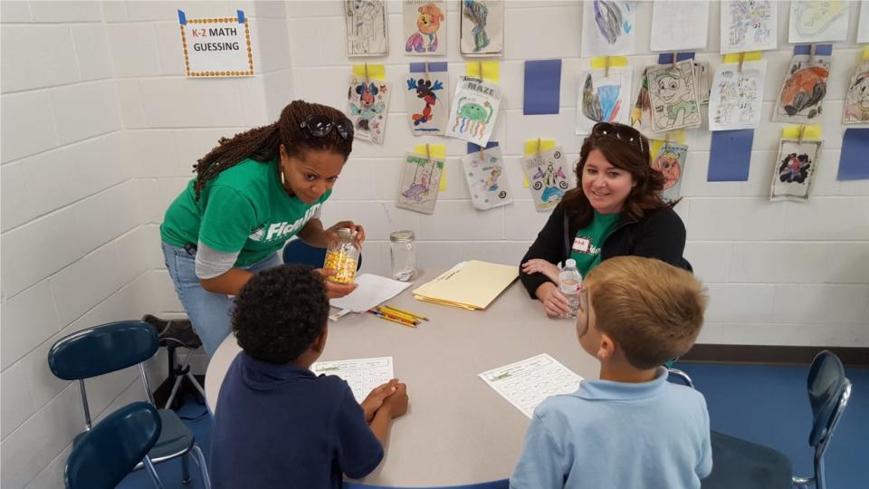 Employees from Fidelity Investments work with students during a company-sponsored event.