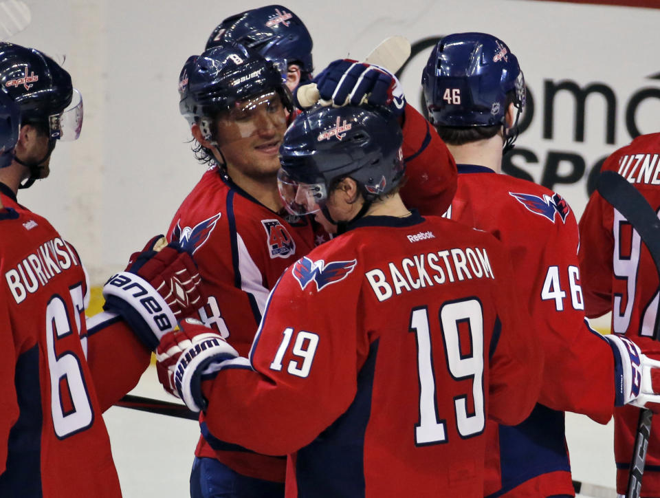 Washington Capitals left wing Alex Ovechkin (8), from Russia, celebrates with center Nicklas Backstrom (19), from Sweden, after an NHL hockey game against the Tampa Bay Lightning, Saturday, Dec. 13, 2014, in Washington. Backstrom had a hat trick, and the Capitals won 4-2. (AP Photo/Alex Brandon)