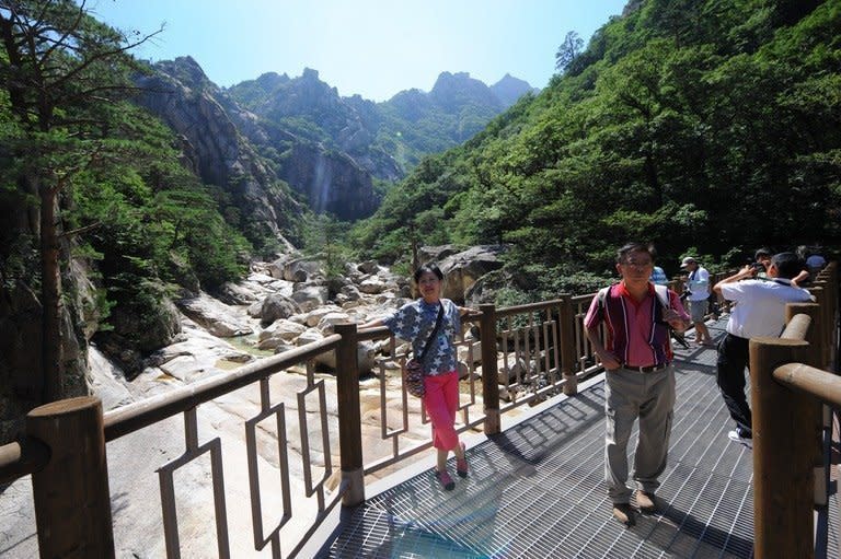 Tourists pose for photos at the Mount Kumgang international tourist zone in North Korea, August 31, 2011. North Korea has reopened a hotline with South Korea as the two sides agreed to weekend talks aimed at mending ties after months of soaring tensions and threats of nuclear war