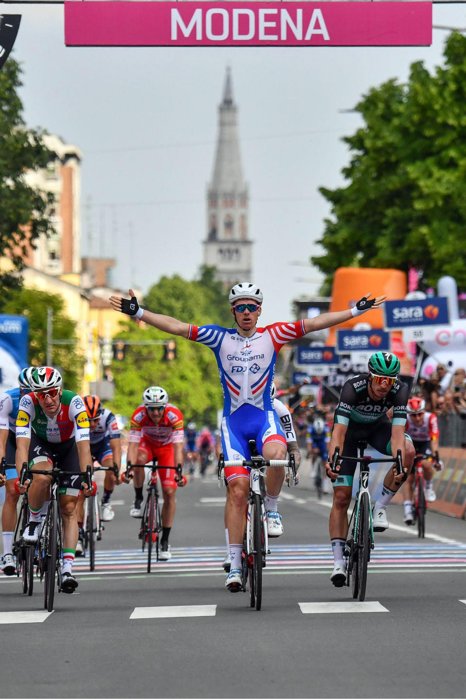 France's Arnaud Demare, center, celebrates after crossing the finish line to win the 10th stage of the Giro d'Italia cycling race from Ravenna to Modena, Italy, Tuesday, May 21, 2019. (Alessandro Di Meo/ANSA via AP)