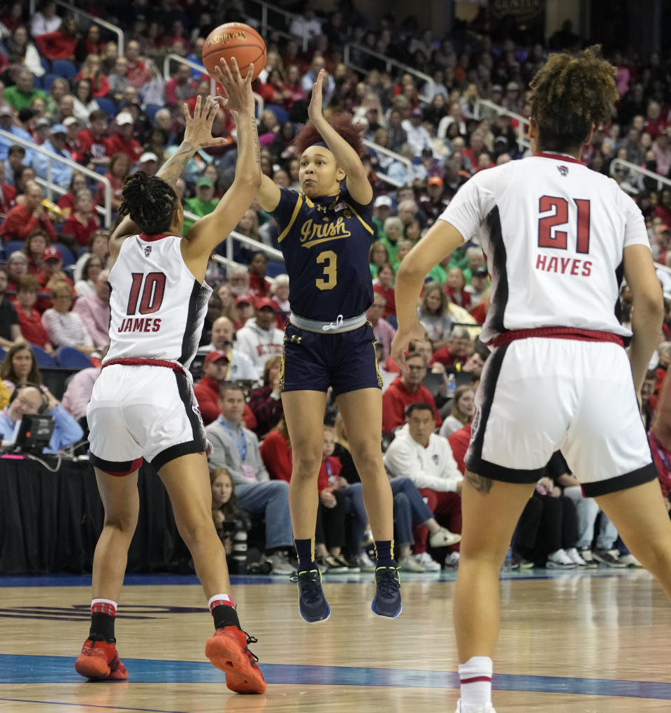 Notre Dame's Hannah Hidalgo (3) shoots against NC State's Aziaha James (10) and Madison Hayes (21) during the second half of an NCAA basketball game for the Women's Atlantic Coast Conference championship in Greensboro, N.C., Sunday, March 10, 2024. (AP Photo/Chuck Burton)