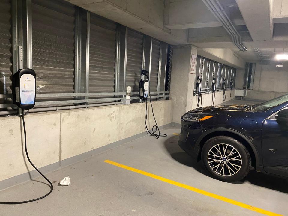 This brand-new parking structure has six level 2 240v electric car chargers, but no outside signs telling drivers how to find them.