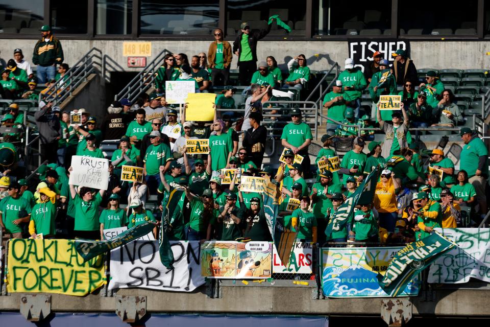 Fans hold signs at Oakland Coliseum to protest the Athletics' planned move to Las Vegas during a game in June.