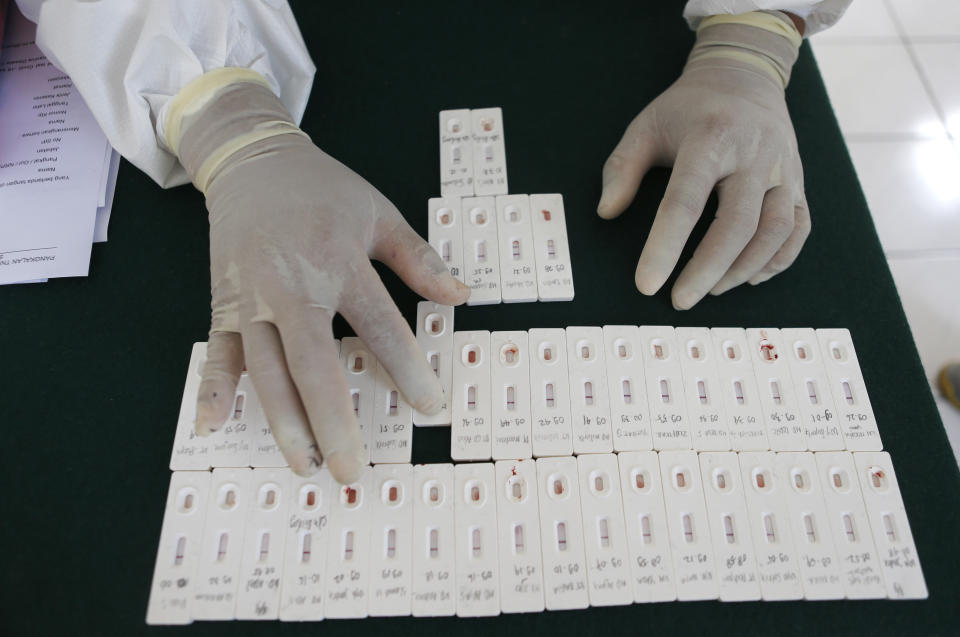 A health worker organizes coronavirus antibody test results at an office in Bali, Indonesia on Friday, Sept. 11, 2020. (AP Photo/Firdia Lisnawati)