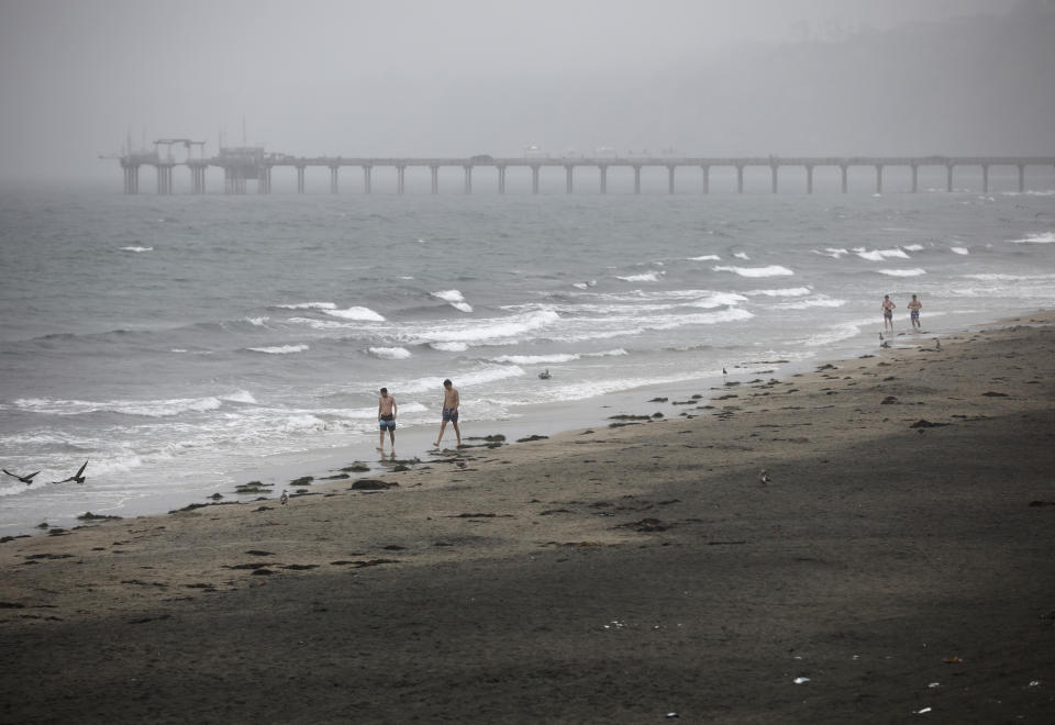 Varias personas caminan en la costa de La Jolla durante el paso de la tormenta tropical Hilary, el domingo 20 de agosto de 2023, en San Diego. (K.C. Alfred/The San Diego Union-Tribune vía AP)