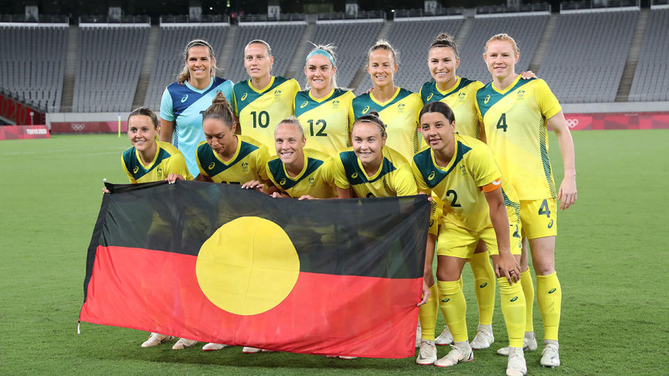 Pictured here, the Matildas squad poses with the Aboriginal flag before a match at the Tokyo Olympic Games. 