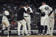 New York Yankees pitching coach Mike Harkey, second from left, talks with starting pitcher Gerrit Cole, third from left, during the third inning of a baseball game against the Baltimore Orioles, Monday May 23, 2022, in New York. (AP Photo/Bebeto Matthews)