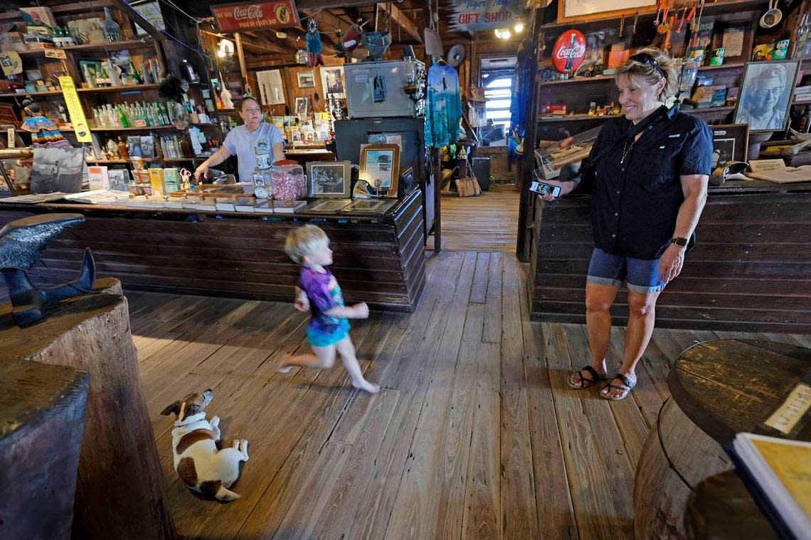 Remington Taylor, 2, runs to see his grandmother, museum director Lynn McMillin, of Chokoloskee, as Sam the dog lays on the floor at the Smallwood Store on Friday.