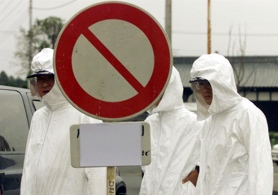 Japanese policemen, wearing protection clothing, close a road connecting to the uranium processing plant in Tokaimura village, about 140km (87 miles) northeast of Tokyo October 1. A chain reaction triggered by Japan's worst-ever nuclear accident had apparently halted by Friday morning, giving officials hope that the corner had been turned in dealing with the crisis.

KM/DL