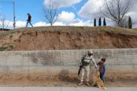 A soldier plays with a dog and a mormon child in La Mora