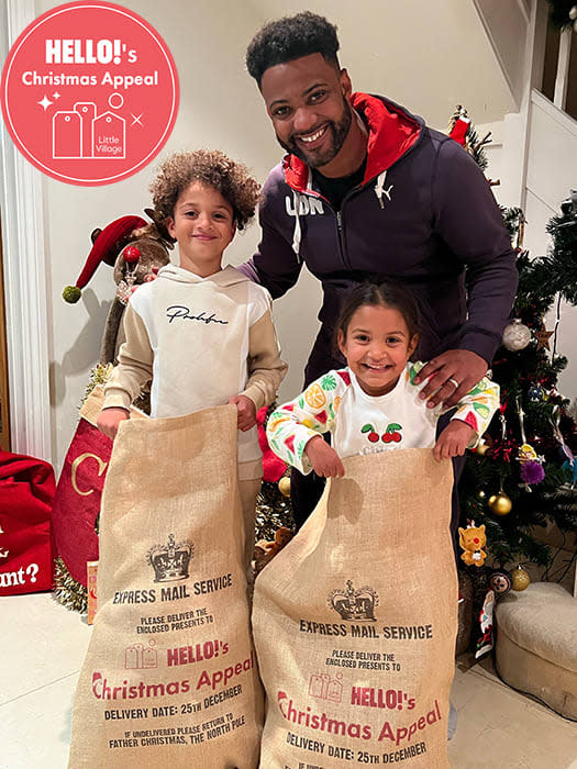 J.B. Gill with his son as daughter posing with their HELLO! Christmas Appeal sacks