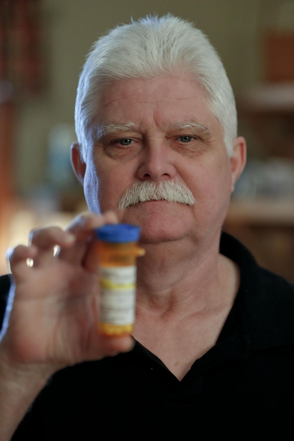 In this April 8, 2019, photo at his home in Derry, Pa., Chuck Pope shows the only medication he uses now to alleviate his rheumatoid arthritis condition. (AP Photo/Keith Srakocic)