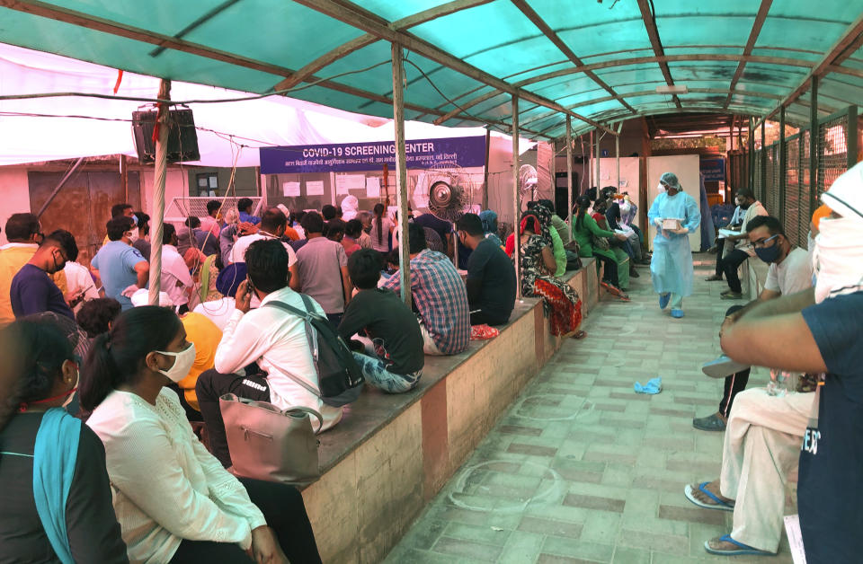 In this Wednesday, June 10, 2020 photo, people stand in a queue for COVID 19 screening at a coronavirus designated hospital in New Delhi, India. Two and a half months of nationwide lockdown kept numbers of infections relatively low in India. But with restrictions easing in recent weeks, cases have shot up, raising questions about whether authorities have done enough to avert catastrophe. Half of Delhi’s 8,200 hospital beds dedicated to COVID-19 patients are already full and officials are projecting more than half a million cases in the city alone by July 31. (AP Photo/Manish Swarup)