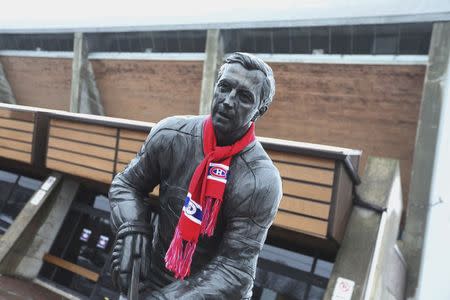 A view of a Jean Beliveau statue draped with a Montreal Canadiens scarf, is seen front of an arena named after Beliveau in Longueuil December 3, 2014. REUTERS/Christinne Muschi