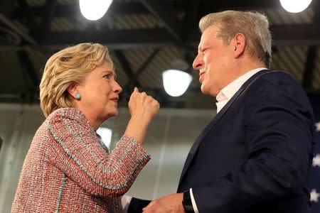 U.S. Democratic presidential nominee Hillary Clinton (L) greets former Vice President Al Gore after they spoke about climate change at a rally at Miami Dade College in Miami, Florida, U.S. October 11, 2016. REUTERS/Lucy Nicholson