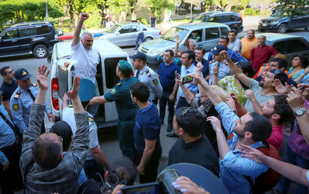 Azerbaijani Journalist Afgan Mukhtarli greets supporters as he is taken to the court in Baku, Azerbaijan, May 31, 2017. REUTERS/Aziz Karimov