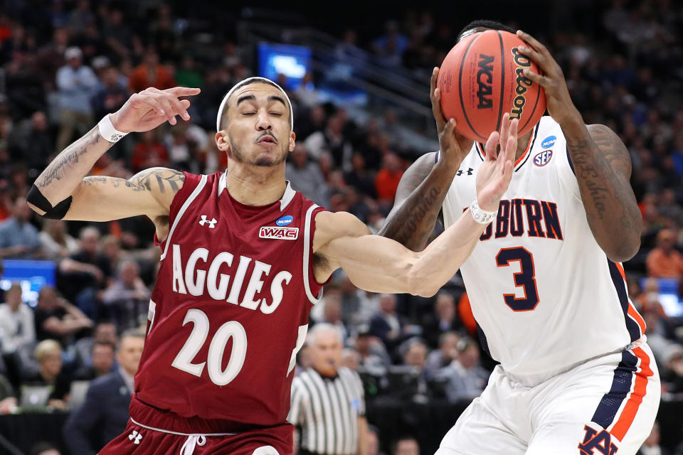 <p>Trevelin Queen #20 of the New Mexico State Aggies battles for the ball with Danjel Purifoy #3 of the Auburn Tigers during the first half in the first round of the 2019 NCAA Men’s Basketball Tournament at Vivint Smart Home Arena on March 21, 2019 in Salt Lake City, Utah. (Photo by Patrick Smith/Getty Images) </p>