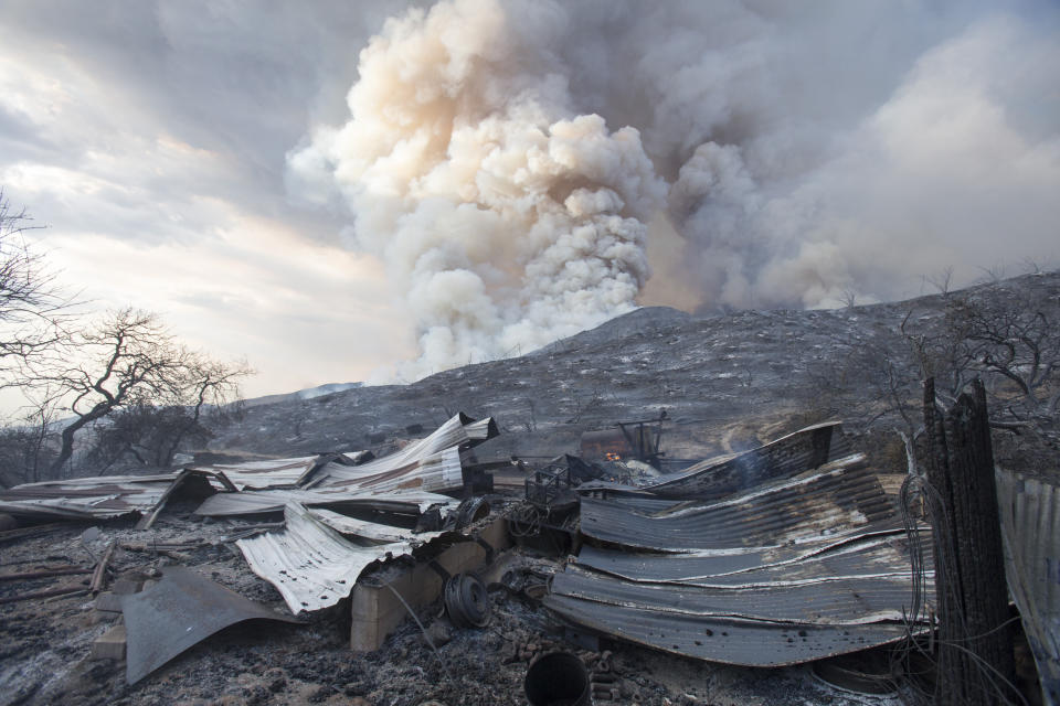 FILE - In this Saturday, Sept. 5, 2020, file photo, a burned structure is seen at a wildfire in Yucaipa, Calif. A couple whose gender reveal ceremony sparked the Southern California wildfire that killed a firefighter in 2020 have been charged with involuntary manslaughter. (AP Photo/Ringo H.W. Chiu, File)