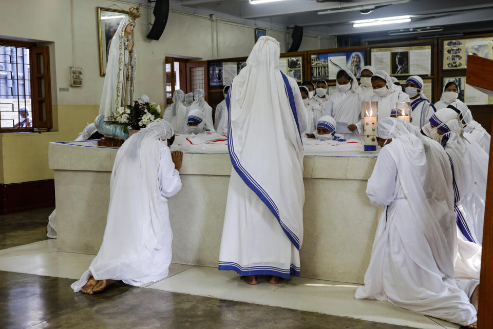 Nuns of the Missionaries of Charity, the order founded by Saint Teresa, wearing masks as precaution against the coronavirus pray by the tomb of the saint to mark her death anniversary in Kolkata, India, Saturday, Sept. 5, 2020. The Nobel Peace Prize winning Catholic nun who spent 45-years serving for the poor, sick, orphaned, and dying, died in Kolkata on this day in 1997 at age 87. (AP Photo/Bikas Das)