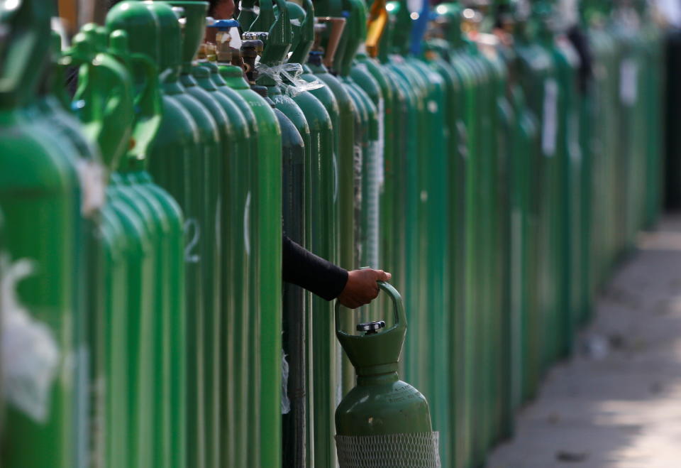 秘魯確診超過百萬，民眾手持空氧氣罐，等待補充。圖片來源：Reuters。