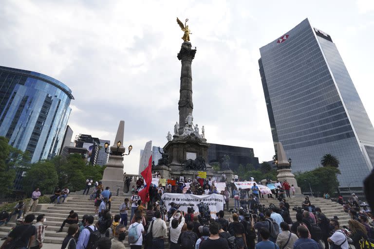 Periodistas sostienen fotos y pancartas que mencionan a colegas asesinados durante una protesta para llamar la atención sobre la última ola de asesinatos de periodistas en el monumento Ángel de la Independencia en la Ciudad de México, el lunes 9 de mayo de 2022. 