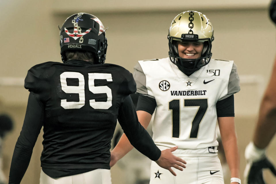 In this image provided by Vanderbilt Athletics, Vanderbilt kicker Sarah Fuller, right, slaps hands with a teammate during NCAA college football practice, Wednesday, Nov. 25, 2020, in Nashville, Tenn. Fuller, a goalkeeper on the Commodores' women's soccer team, will don a football uniform on Vanderbilt's sideline and she is poised to become the first woman to play in a Power 5 game when the Commodores take on Missouri. (Vanderbilt Athletics via AP)