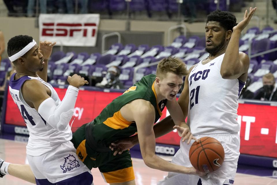 North Dakota State forward Grant Nelson, center, loses control of the ball on a drive to the basket as TCU forward Kevin Easley Jr., left, and Kevin Samuel, right, defends in the first half of an NCAA college basketball game in Fort Worth, Texas, Tuesday, Dec. 22, 2020. (AP Photo/Tony Gutierrez)