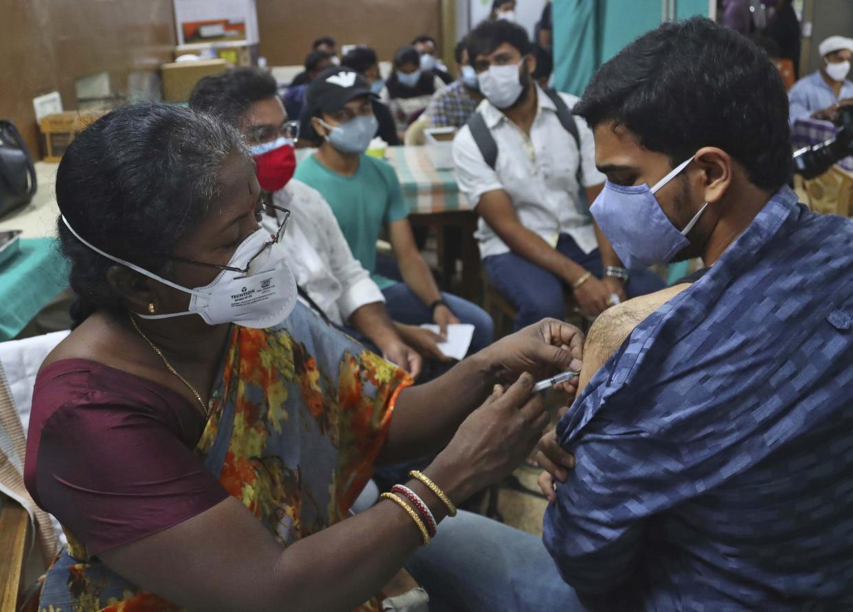 A health worker administers the Covishield, Serum Institute of India's version of the AstraZeneca vaccine, during a special vaccination drive for students traveling overseas, in Hyderabad, India, Friday, June 11, 2021. (AP Photo/Mahesh Kumar A.)