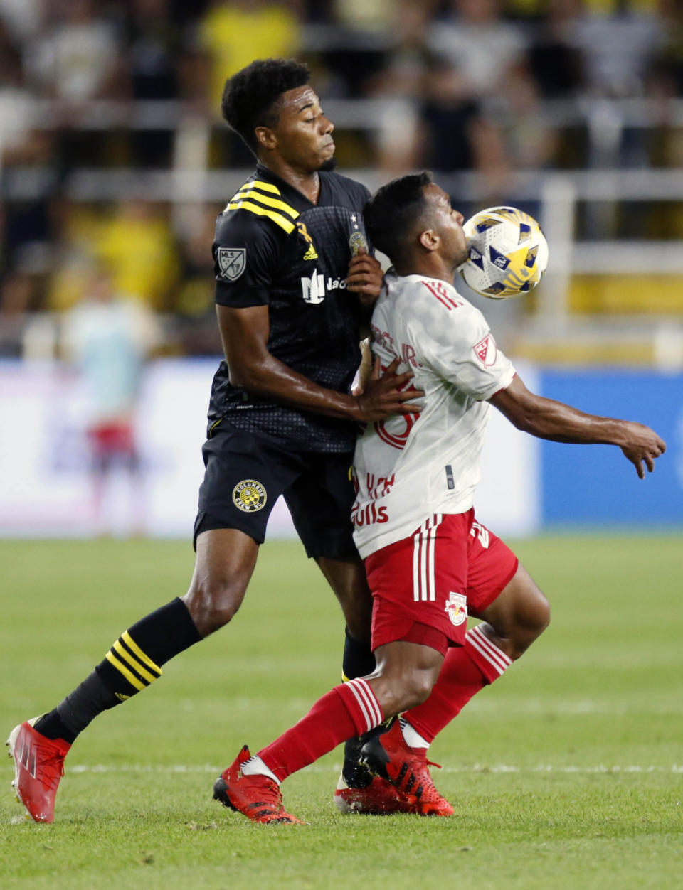 New York Red Bulls midfielder Cristian Casseres, right, heads the ball in front of Columbus Crew defender Saad Abdul-Salaam during the first half of an MLS soccer match in Columbus, Ohio, Tuesday, Sept. 14, 2021. (AP Photo/Paul Vernon)