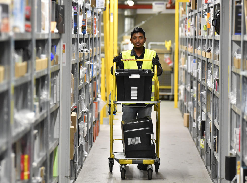 A worker collects goods for purchase orders at the giant storehouse of the Amazon Logistic Center in Rheinberg, Germany, Wednesday, Nov. 14, 2018. Amazon in Rheinberg hired extra workers for the Christmas sales. (AP Photo/Martin Meissner)