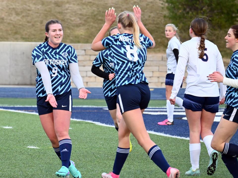 Petoskey's Lauren Cole (9) celebrates with teammate Lily Premo during Friday's season opener against Boyne City, which Cole recorded a hat trick in.