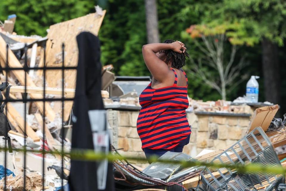 A person reacts to the scene of a $3 million home on Lake Norman collapsed in Mooresville, N.C., at about 12 a.m. on Tuesday, Aug. 22, 2023. Mooresville firefighters found one person dead in the 25-foot pile of rubble.