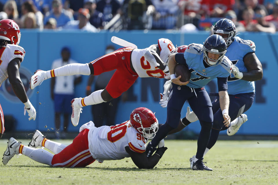 Tennessee Titans quarterback Ryan Tannehill (17) runs with the ball as Kansas City Chiefs defenders Jarran Reed (90) and Willie Gay (50) try to bring him down in the first half of an NFL football game Sunday, Oct. 24, 2021, in Nashville, Tenn. (AP Photo/Wade Payne)