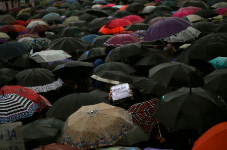 A woman holds up a sign that reads "We want us alive" amongst umbrellas during a demonstration to demand policies to prevent gender-related violence, in Buenos Aires, Argentina, October 19, 2016. REUTERS/Marcos Brindicci