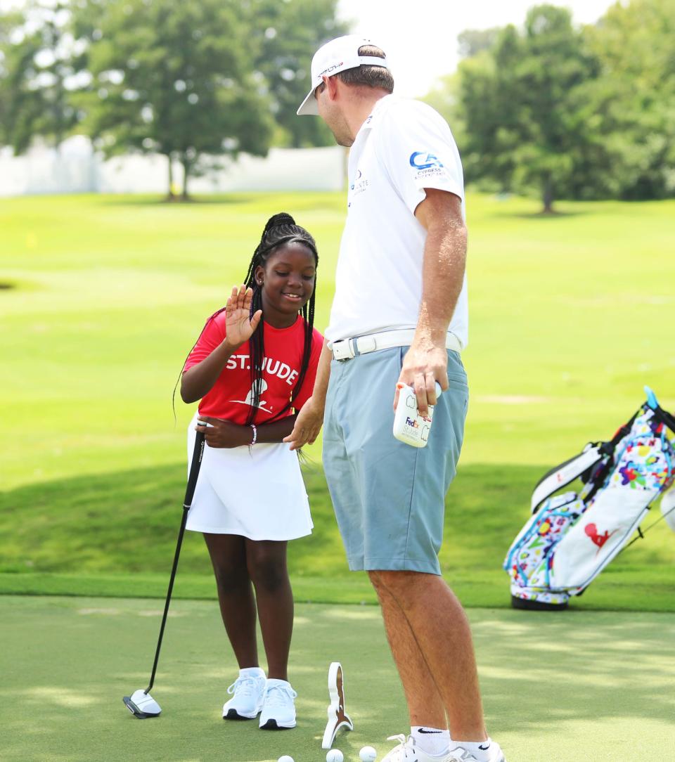 St. Jude patient Azalea gets a high-five from professional golfer Harris English after she hit the ball into the hole during the TaylorMade/PING putt-around on Aug. 8, 2023, at TPC Southwind in Memphis. The FedEx St. Jude Championship is Aug. 10-13 at TPC Southwind.