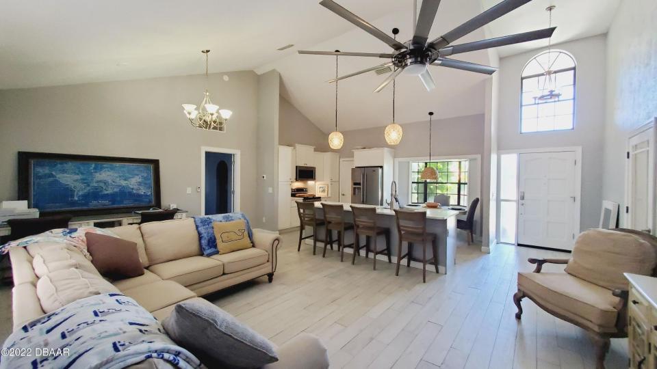 The beautifully updated open floor plan highlights plank-tile flooring and the kitchen with a 10-foot island, quartz countertops, soft-close cabinets and matching Maytag appliances.