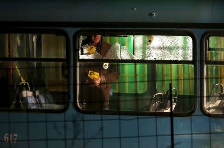 A forensic personnel places makers in a bus with windows broken by bullets after an attack in Sarajevo, November 19, 2015. REUTERS/Dado Ruvic