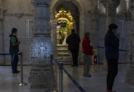 Hindu worshippers offer prayers at the BAPS Shri Swaminarayan Mandir, also known as the Neasden Temple, in London on Friday, July 3, 2020. The temple of carved stone constructed according to ancient Vedic architectural texts usually welcomes thousands of visitors a day but now gets just a trickle of devotees who book appointments online first to keep the crowds down. (AP Photo/Elizabeth Dalziel)