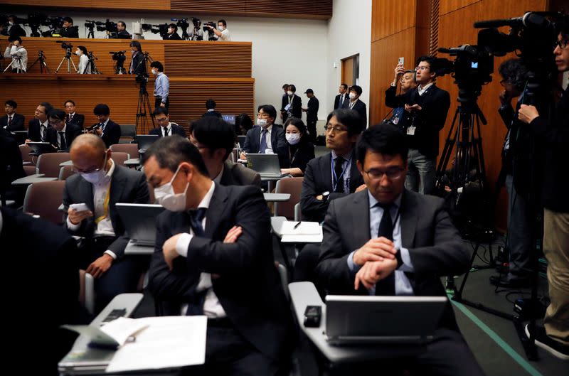 Media members wearing protective face masks, following an outbreak of the coronavirus, sit before a news conference by Japan's Prime Minister Shinzo Abe at his official residence in Tokyo