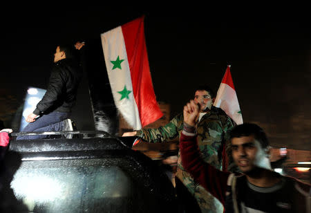 Supporters of Syria's President Bashar al-Assad carry their national flags as they celebrate what they say is the Syrian army's victory against the rebels, in Aleppo, Syria December 12, 2016. REUTERS/Omar Sanadiki