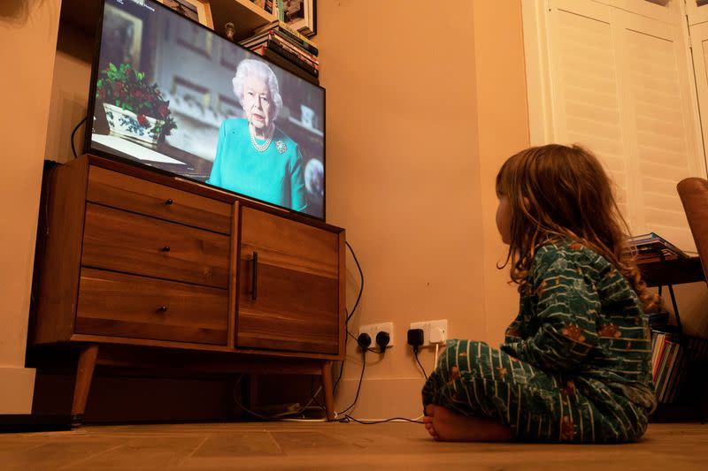 FILE PHOTO: Isaac (4) watches Queen Elizabeth II during a televised address to the nation