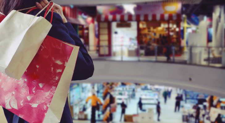 a person standing in a shopping mall with a bag in their hand