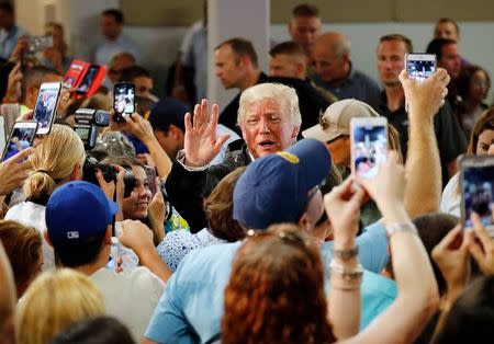 U.S. President Donald Trump waves to local residents affected by Hurricane Maria as he helps hand out supplies at a disaster relief distribution center at Calgary Chapel in San Juan, Puerto Rico, U.S., October 3, 2017. REUTERS/Jonathan Ernst