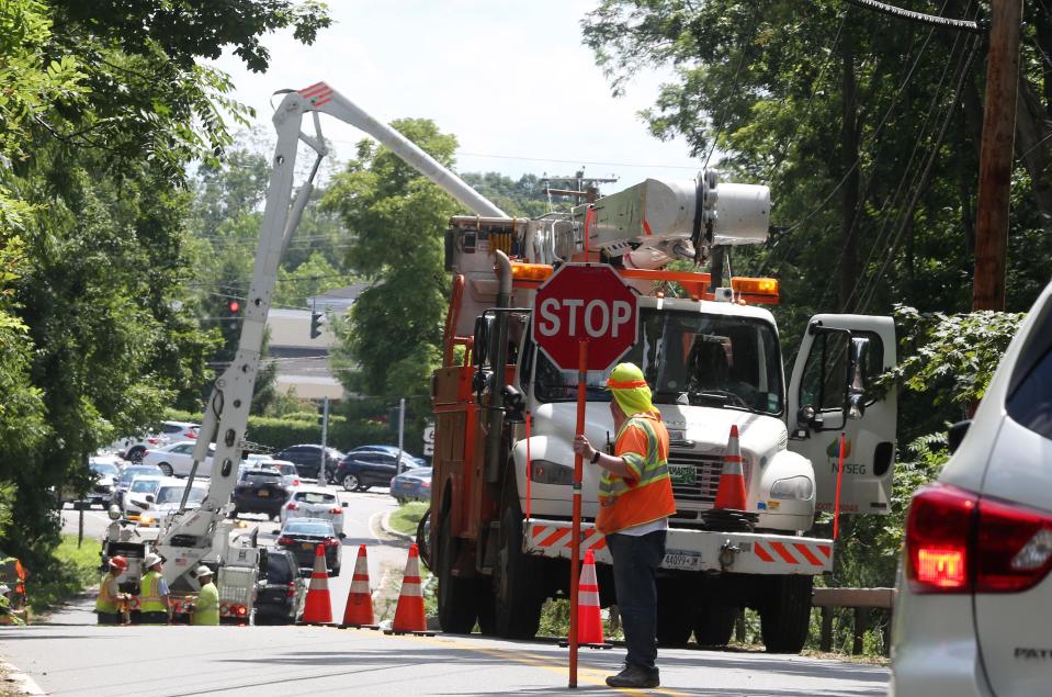 A NYSEG workers closes a portion of Baldwin Place Road in Mahopac as crews work on utility lines following Tropical Storm Isaias  Aug. 5, 2020.