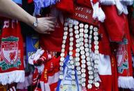 A fan looks at tributes on the Shankly gates before a memorial service to mark the 25th anniversary of the Hillsborough disaster at Anfield in Liverpool, northern England April 15, 2014. REUTERS/Darren Staples