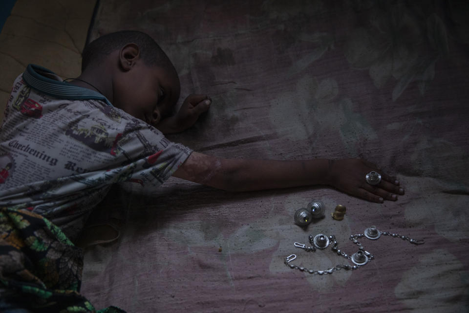Tigrayan 5-year-old refugee Micheale Gebremariam plays with jewelry belonging to his deceased mother, Letay, inside the family's shelter in Hamdayet, eastern Sudan, near the border with Ethiopia, on March 14, 2021. (AP Photo/Nariman El-Mofty)
