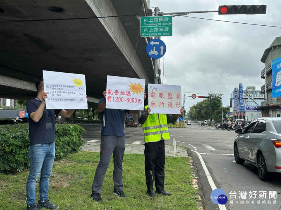 南屯區向上路與環中路交叉口已設置監控器，監控行經車輛亂丟垃圾情形，中市環保局人員在路口進行宣導。(圖/記者賴淑禎攝)